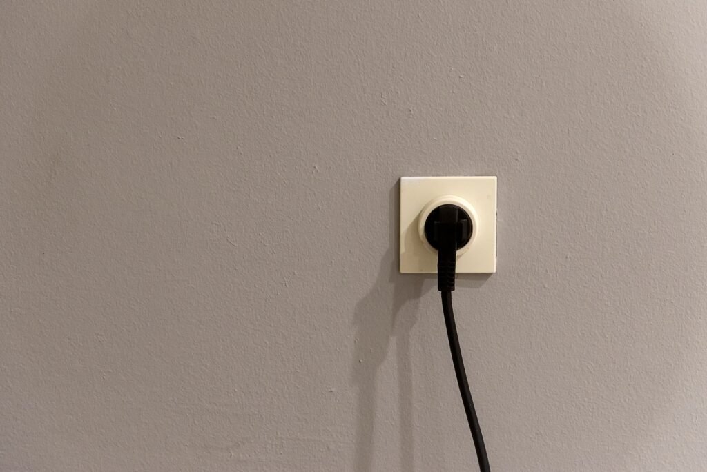 Black appliance plug pushed into a cream wall socket, the first check when a dehumidifier will not start