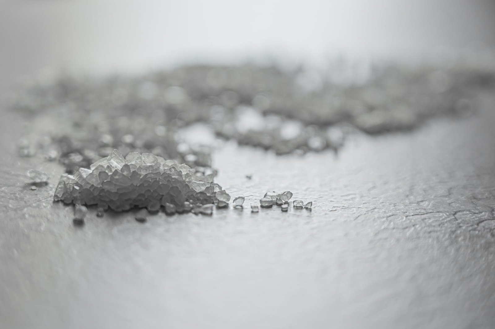 Coarse rock salt scattered on a grey surface, the most commonly recommended natural dehumidifier
