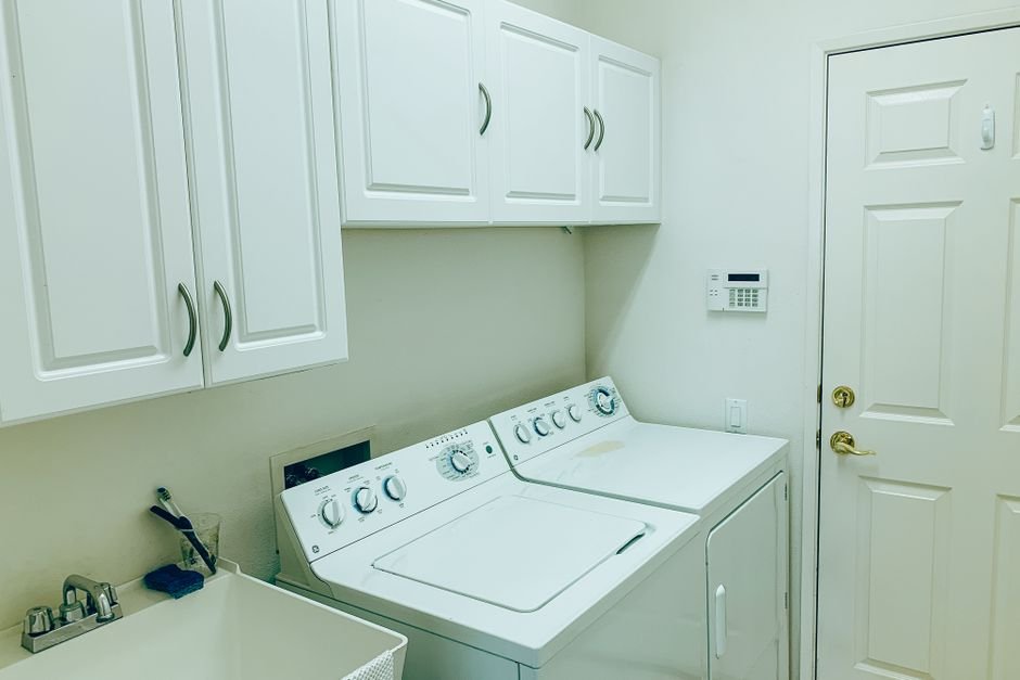 Laundry room with a utility sink, a common destination for a dehumidifier drain hose where there is no floor drain