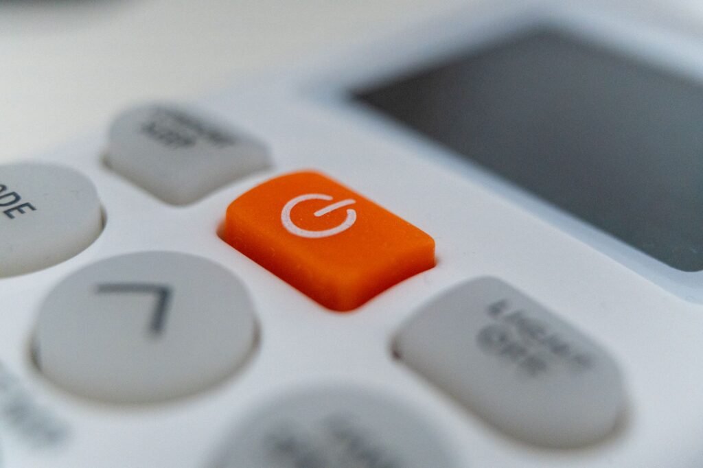 Close-up of an orange power button on an appliance control panel