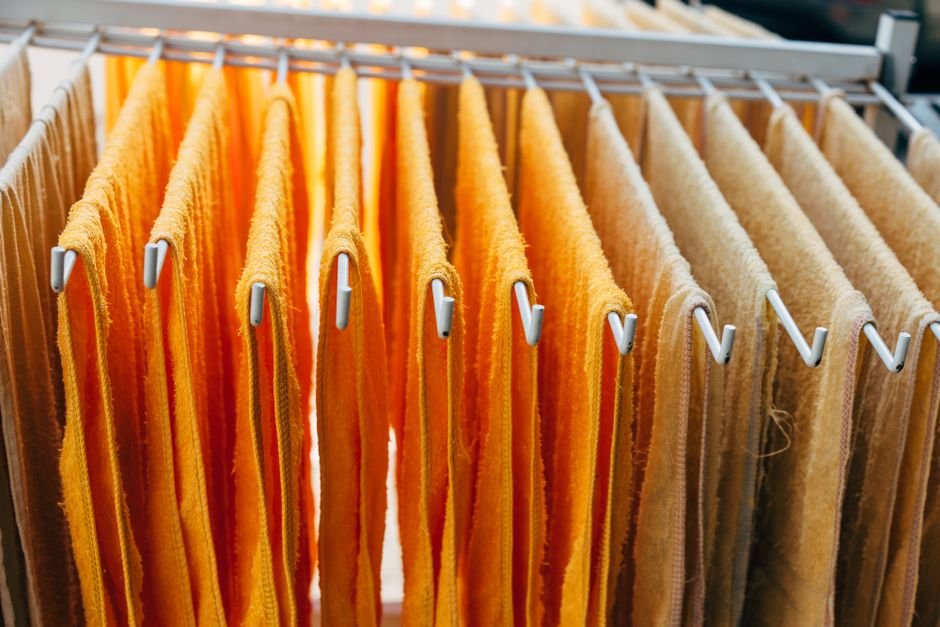 Towels hung with gaps on an indoor drying rack so air reaches both faces of the fabric, which roughly doubles drying speed