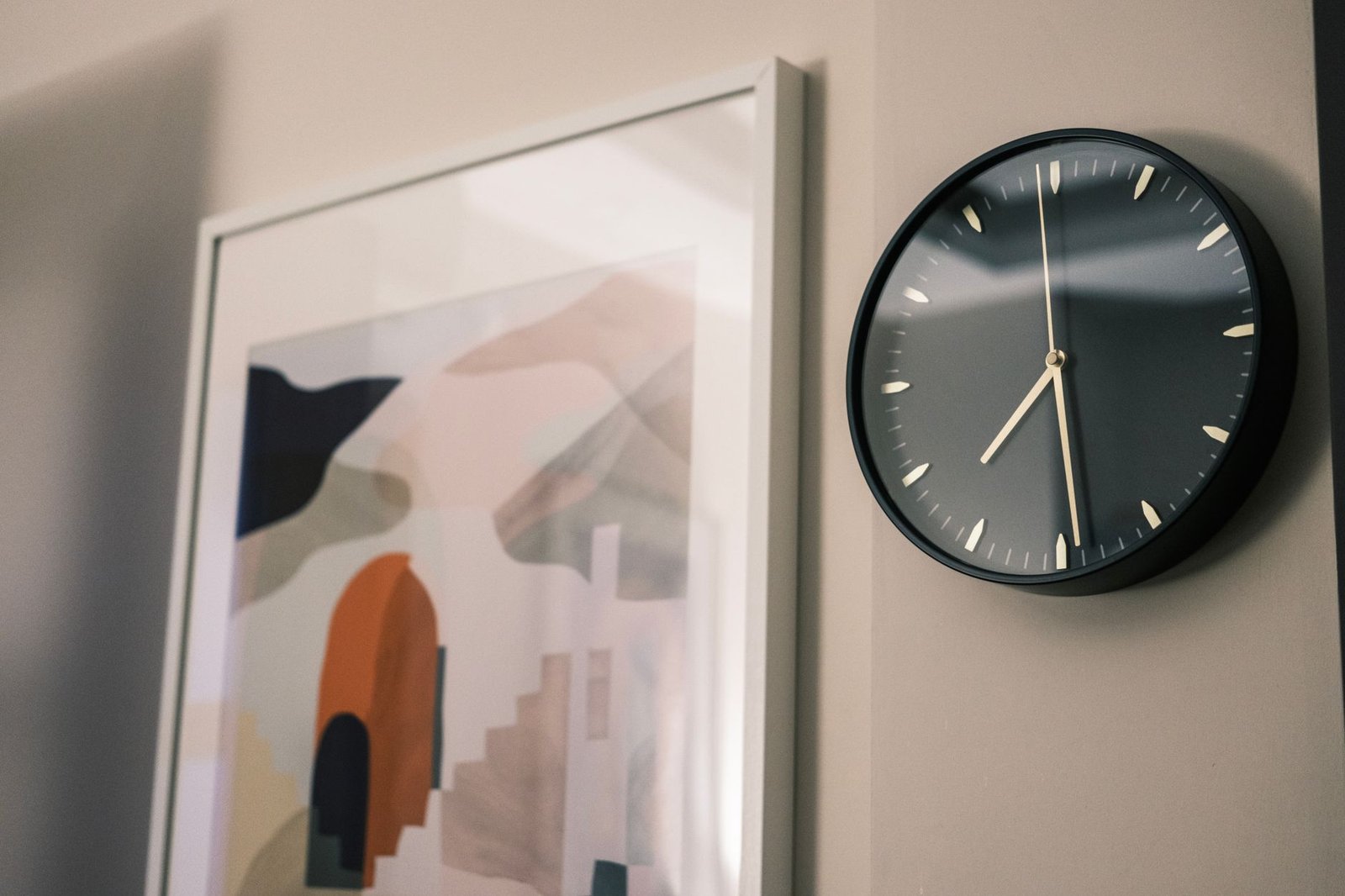 Modern wall clock beside a framed print, marking dehumidifier running hours