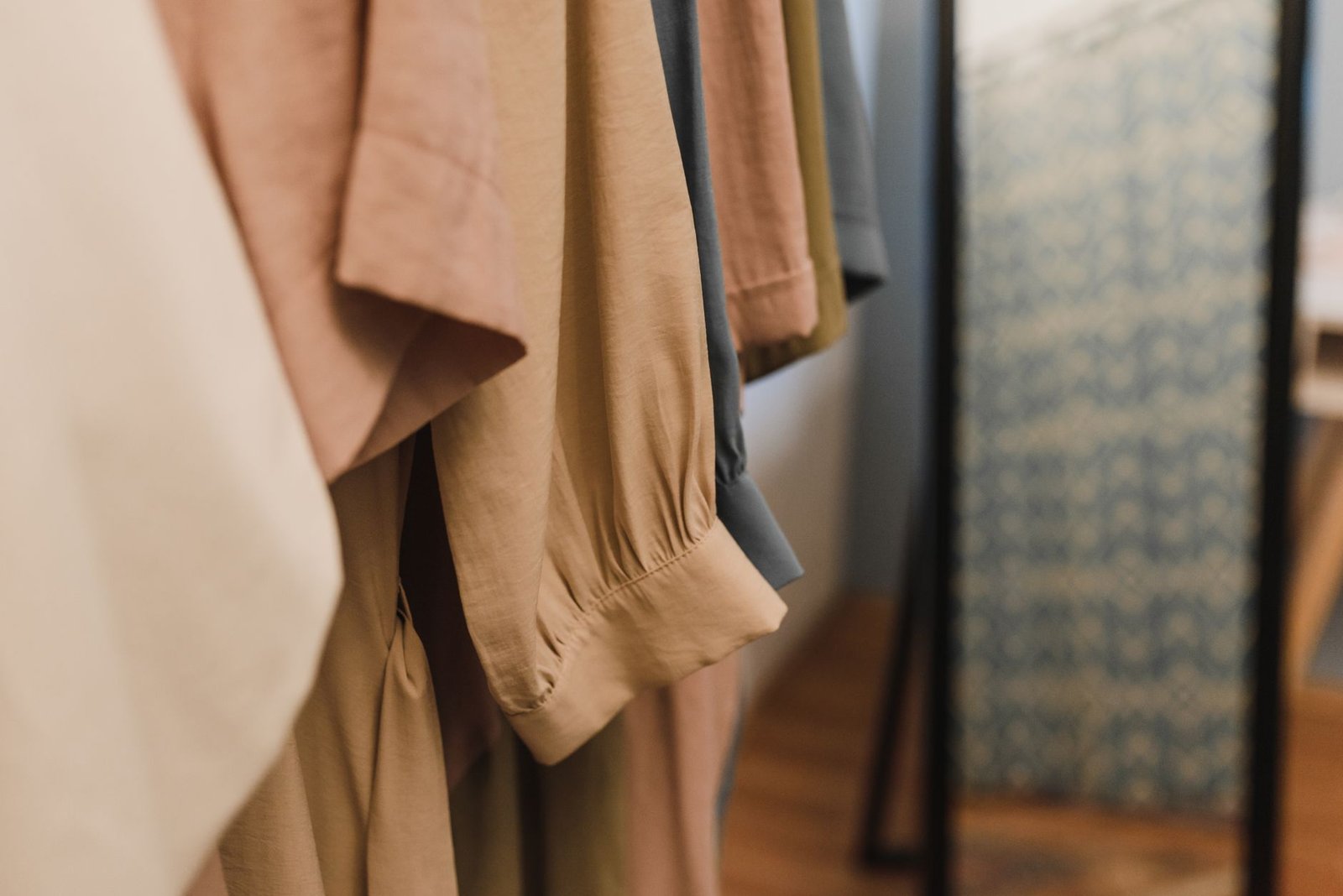 Soft cotton and linen-look shirts hanging close together on a wardrobe rail