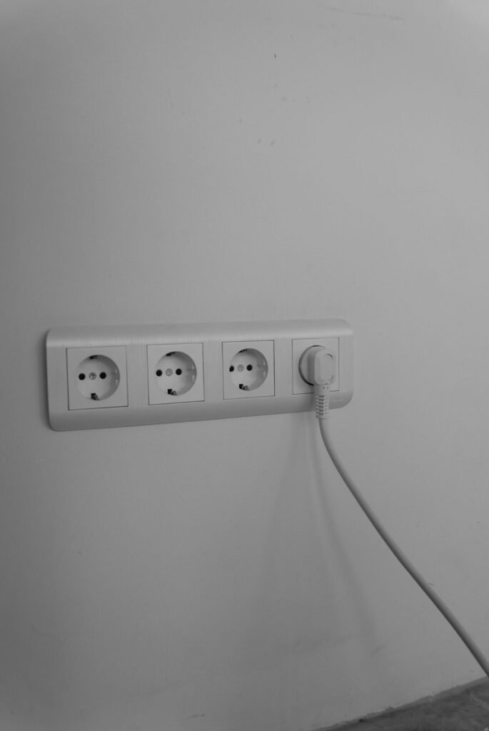 A white plug and lead in a row of four wall sockets, the simple connection a dehumidifier depends on after a power cut