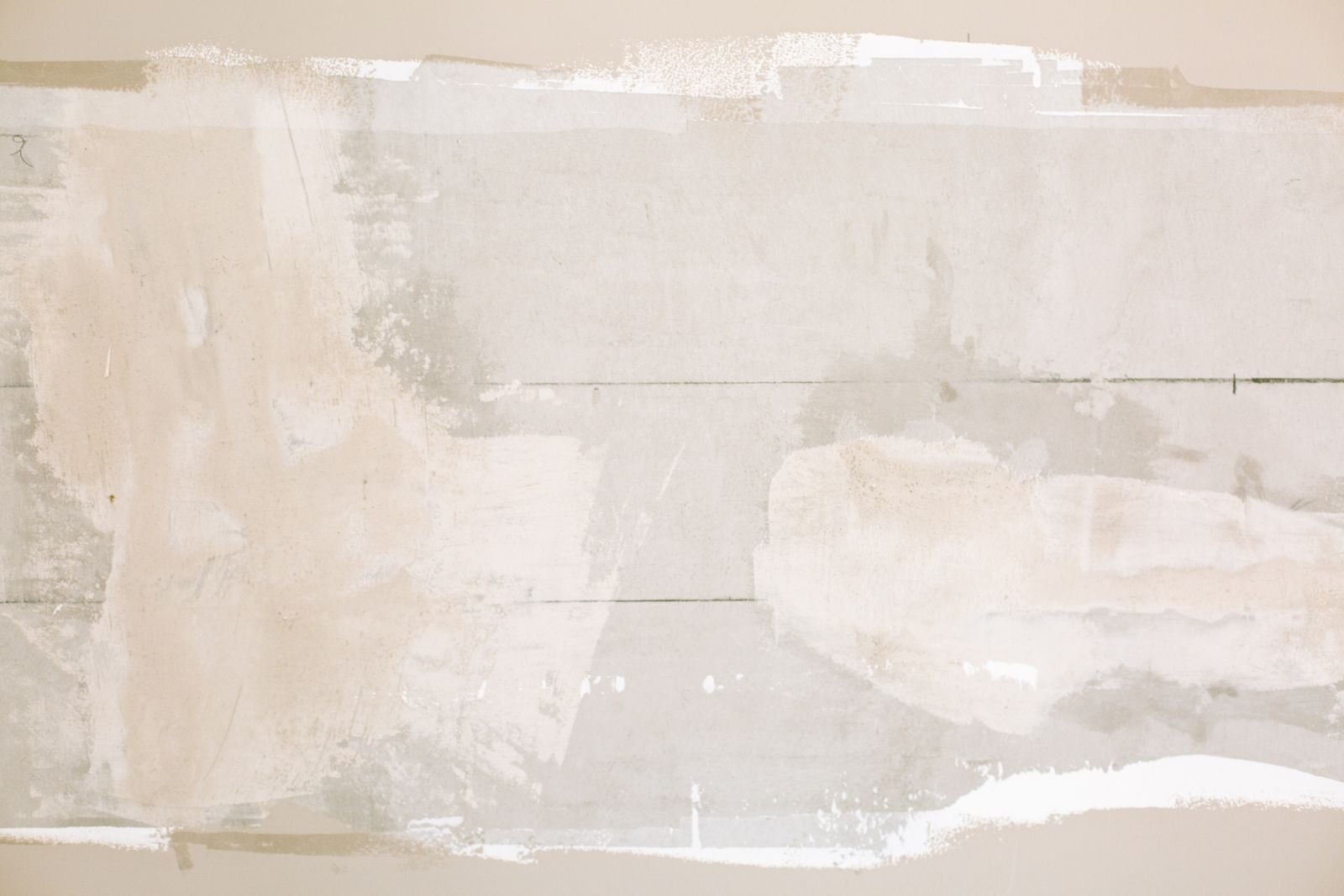 Joint compound smoothed over plasterboard seams on an interior wall, where paper tape and filler hold moisture longest
