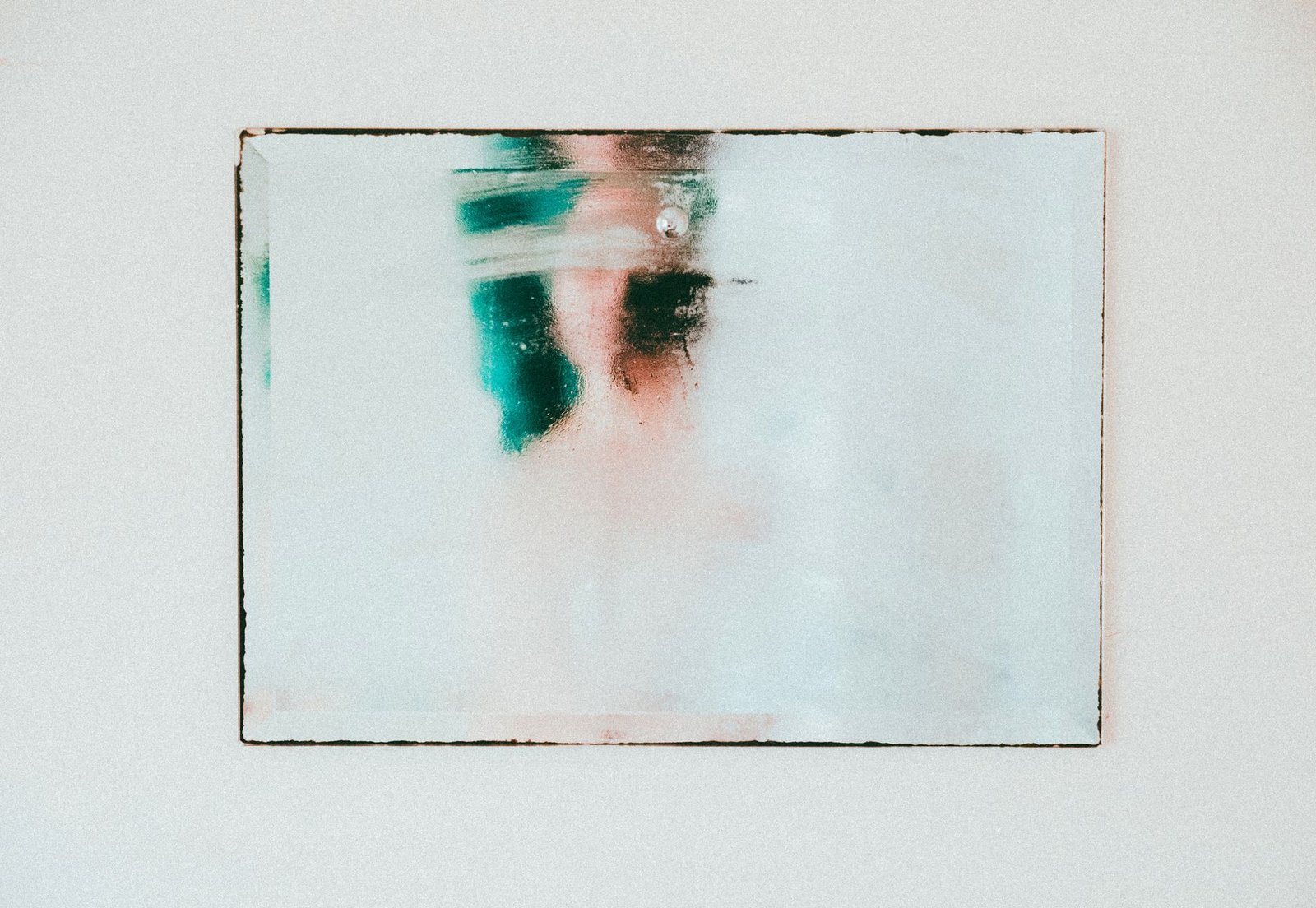 Fogged bathroom mirror after a shower, showing the same warm moist air that settles on a cold cistern