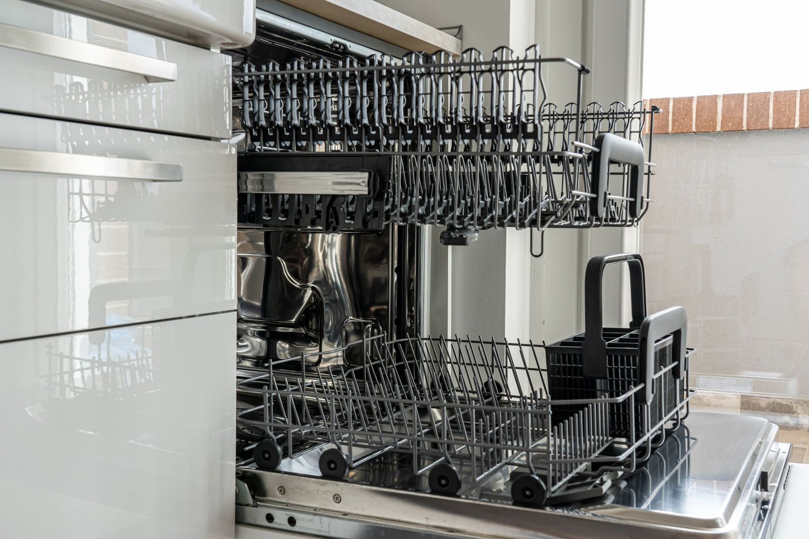 Open dishwasher with the racks pulled out after a wash cycle