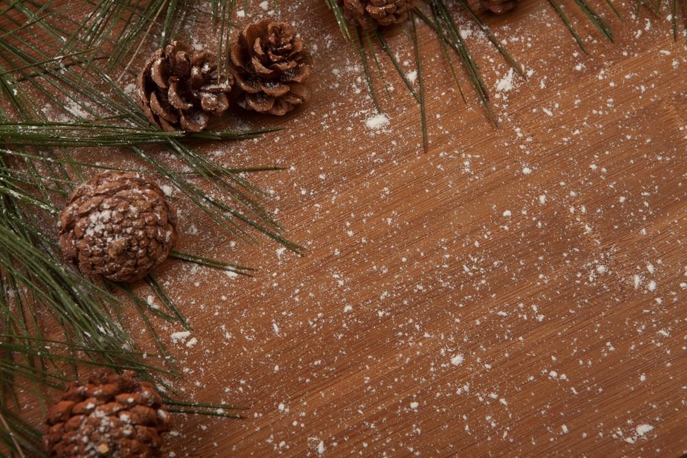 Small pine cones with their scales closed on a wooden table, a folk humidity cue rather than a measuring tool