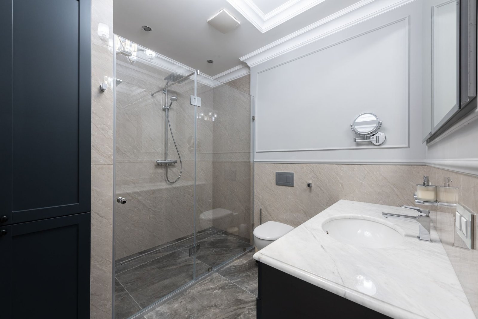 Shower room with a glass screen and basin, the kind of room where an extractor fan has to clear steam