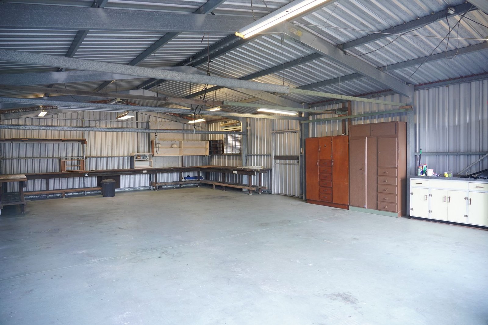 Empty steel-clad workshop with a concrete floor and cabinets, a typical storage space for a portable dehumidifier