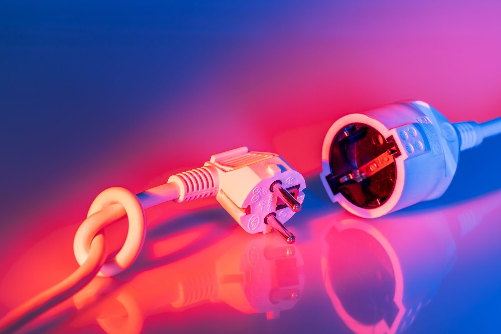 Unplugged white mains plug and cord end lying apart, the first step when an appliance smells of burning