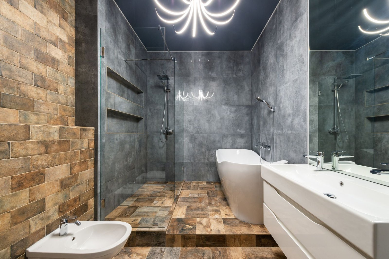 Bathroom with a walk-in glass shower screen, a freestanding bath and a tiled wall