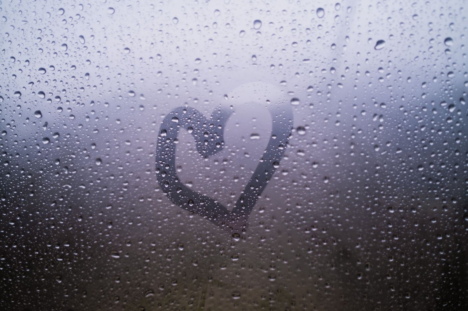 Heart drawn in the beaded moisture on a cold window pane, surface moisture that a sensor in the middle of the room does not read