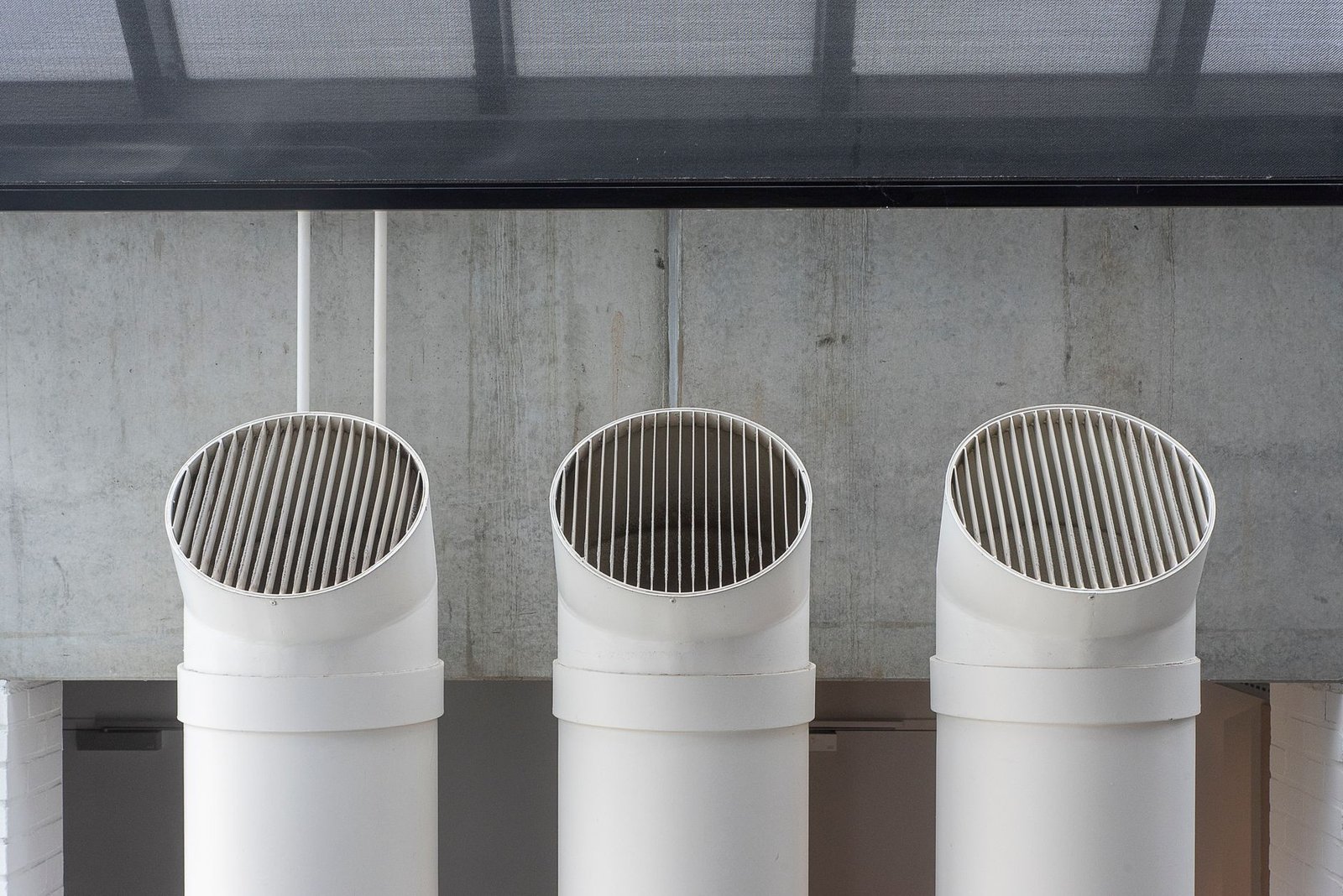 Three white ventilation tubes with grilled open ends, an easy route for insects